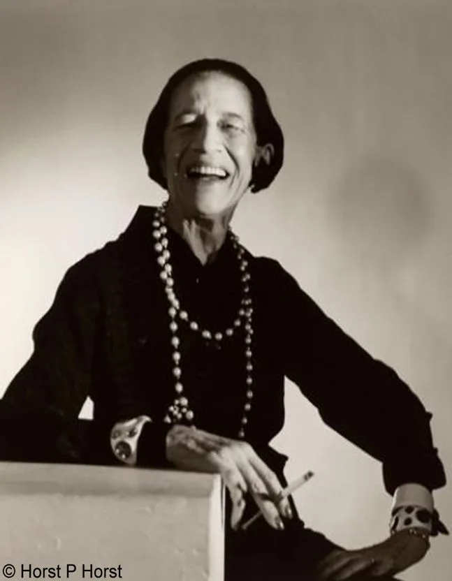 Diana Vreeland in black with strands of pearl necklace smoking
