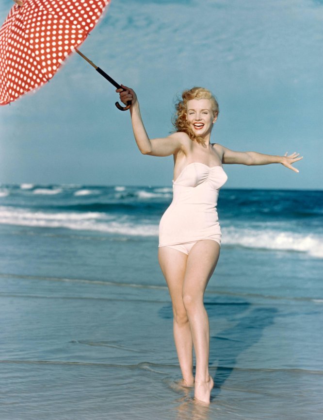 Elegant style icon wardrobe essentials: Marilyn Monroe in swimwear, a one piece pink bathing swimming suit