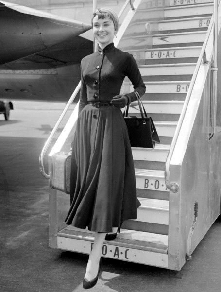 Elegant style icon wardrobe essentials: Audrey Hepburn in little black dress, Heathrow Airport in London, 21 May 1953.