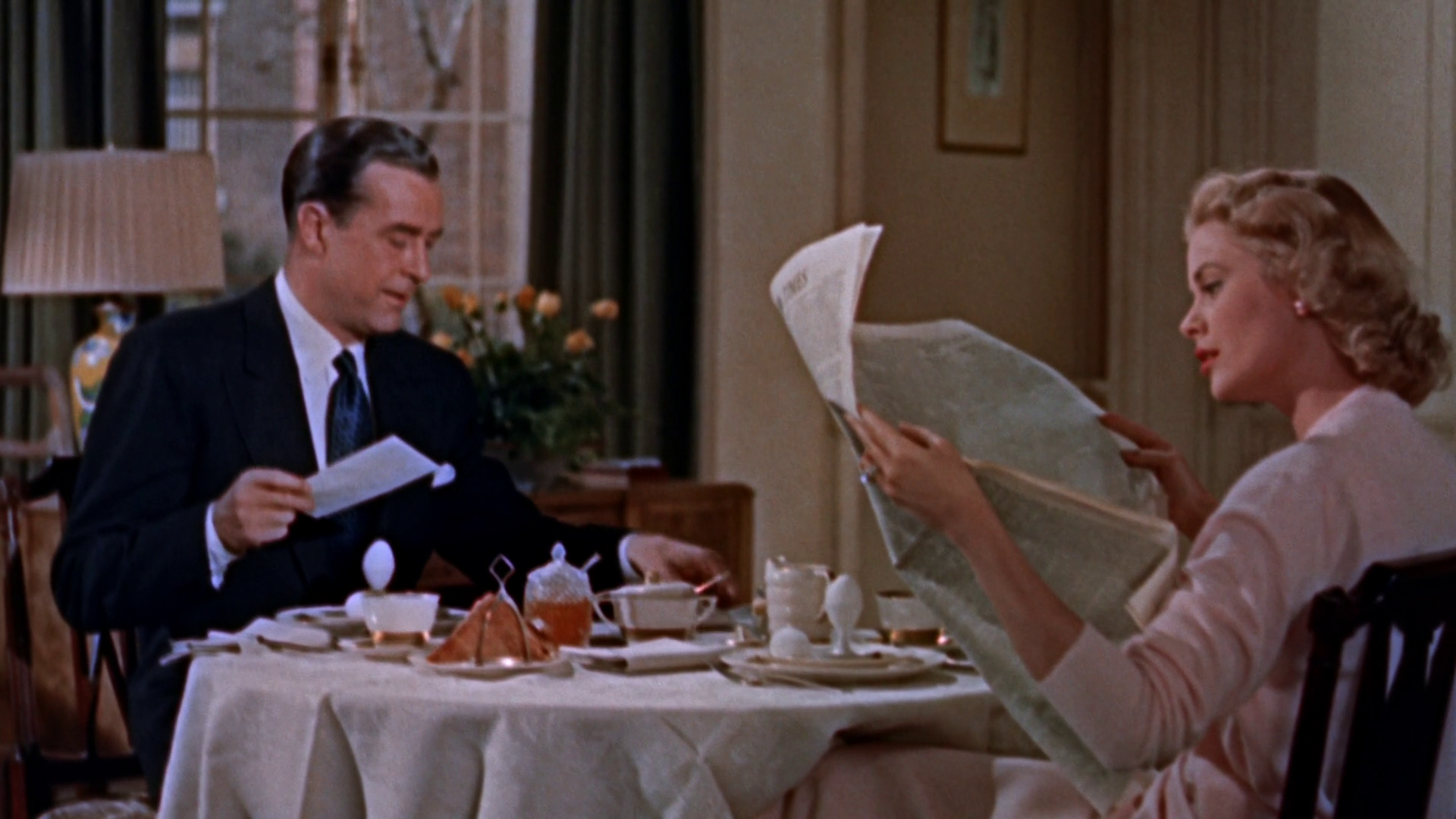 Elegant style icon wardrobe essentials: Grace Kelly in cardigan sweater: Grace Kelly wearing a pink cashmere cardigan sweater in film Dial M for Murder(1954)