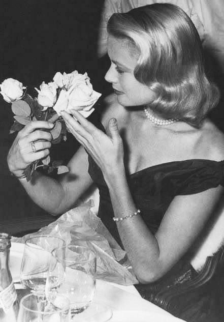 Elegant style icon wardrobe essentials: Grace Kelly in black dress, Cannes Film Festival 1955.
