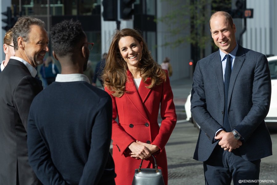 Kate Middleton Duchess of Cambridge custom made/bespoke Alexander McQueen red double breast full length coat with peak lapel for Hold Still photography project at Waterloo Station in London 