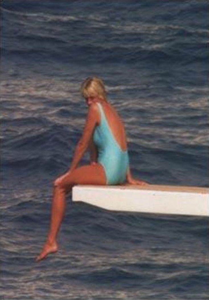 Elegant style icon wardrobe essentials: Princess Diana in swimwear, a one piece pale blue swimsuit