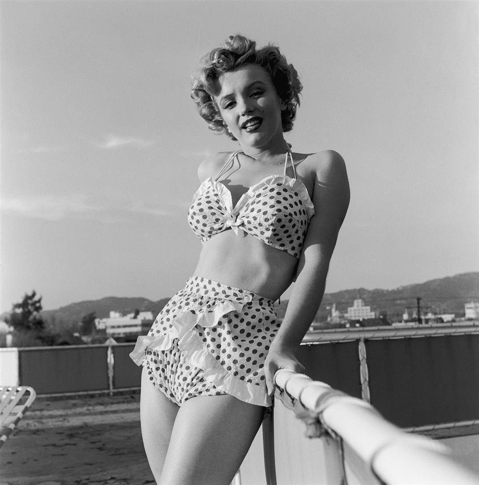 Elegant style icon wardrobe essentials: Marilyn Monroe in swimwear, a two piece halter neck bikini
