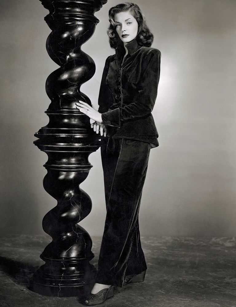 Lauren Bacall in high collar velvet jacket and pants.