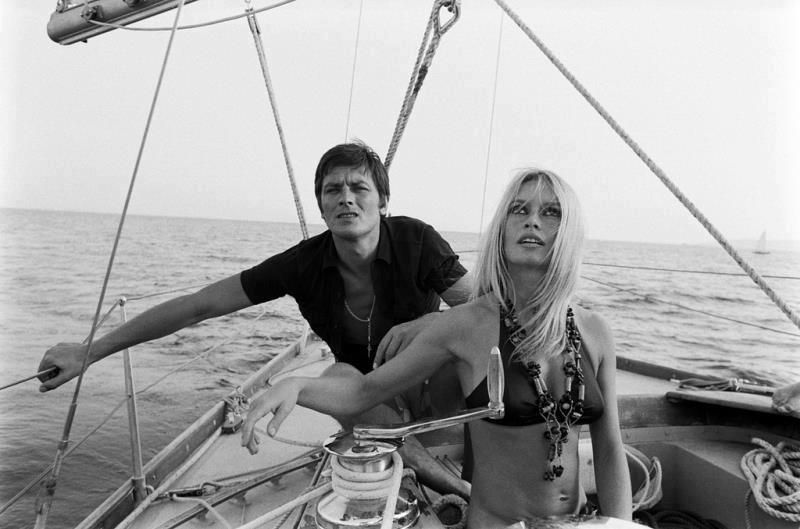 Elegant style icon wardrobe essentials: Brigitte Bardot in swimwear, a two piece bikini in black, with Alain Delon, August 1968
