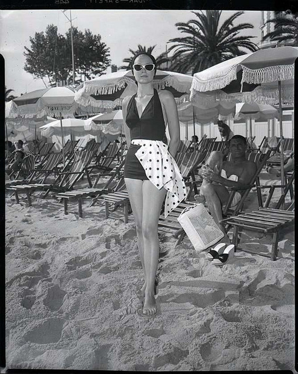 Elegant style icon wardrobe essentials: Grace Kelly in swimwear, a halter neck one piece swimming suit, on the set of film To Catch a Thief(1956)