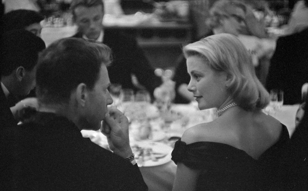 Elegant style icon wardrobe essentials: Grace Kelly in black dress, with Jean-Pierre Aumont. Cannes Film Festival 1955.