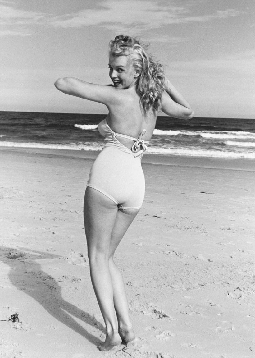 Elegant style icon wardrobe essentials: Marilyn Monroe in swimwear, a one piece pink bathing swimming suit