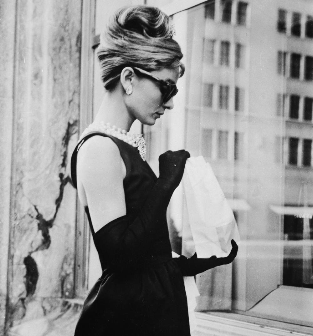 Elegant style icon wardrobe essentials: Audrey Hepburn in black floor length dress designed by Hubert de Givenchy, in film Breakfast at Tiffany's(1961)