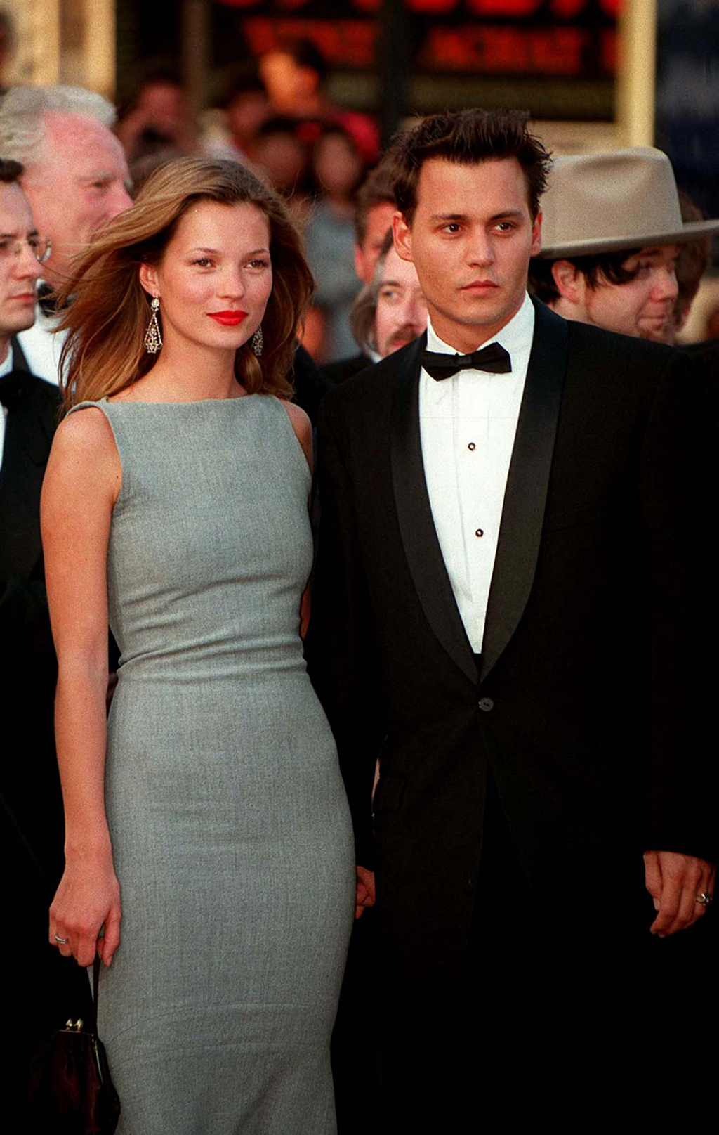 Kate Moss in a sleeveless grey shift dress by Narciso Rodriguez with Johnny Depp in a tuxedo on the red carpet at Cannes, 10 May 1997