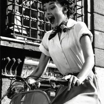 Audrey Hepburn in a white shirt and neck scarf riding a Vespa, Roman Holiday (film, 1953)