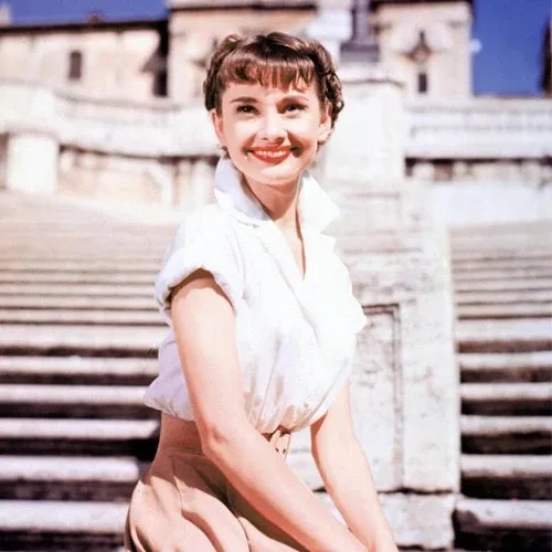 Colorized photo of Audrey Hepburn in a white shirt on the Spanish Steps, Roman Holiday