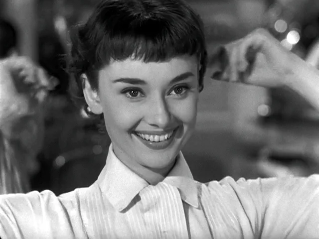 Audrey Hepburn smiling in a white shirt with her new short hair, Roman Holiday (film, 1953)