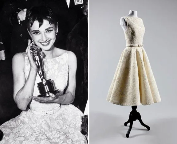 Audrey Hepburn with her Oscar beside the white lace dress on a stand