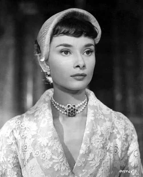 Audrey Hepburn in the lace dress in Roman Holiday, worn with a pearl choker and Juliet style cap