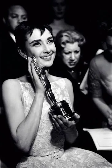 Audrey Hepburn holding her Oscar in the white lace dress, 1954