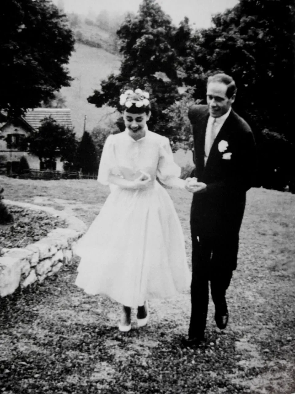 Audrey Hepburn in her tea-length wedding dress with Mel Ferrer on the lawn, Bürgenstock, 1954