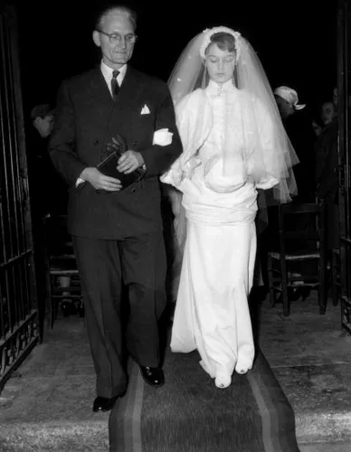 Brigitte Bardot in her white wedding dress and veil walking down the church aisle, Paris, 1952
