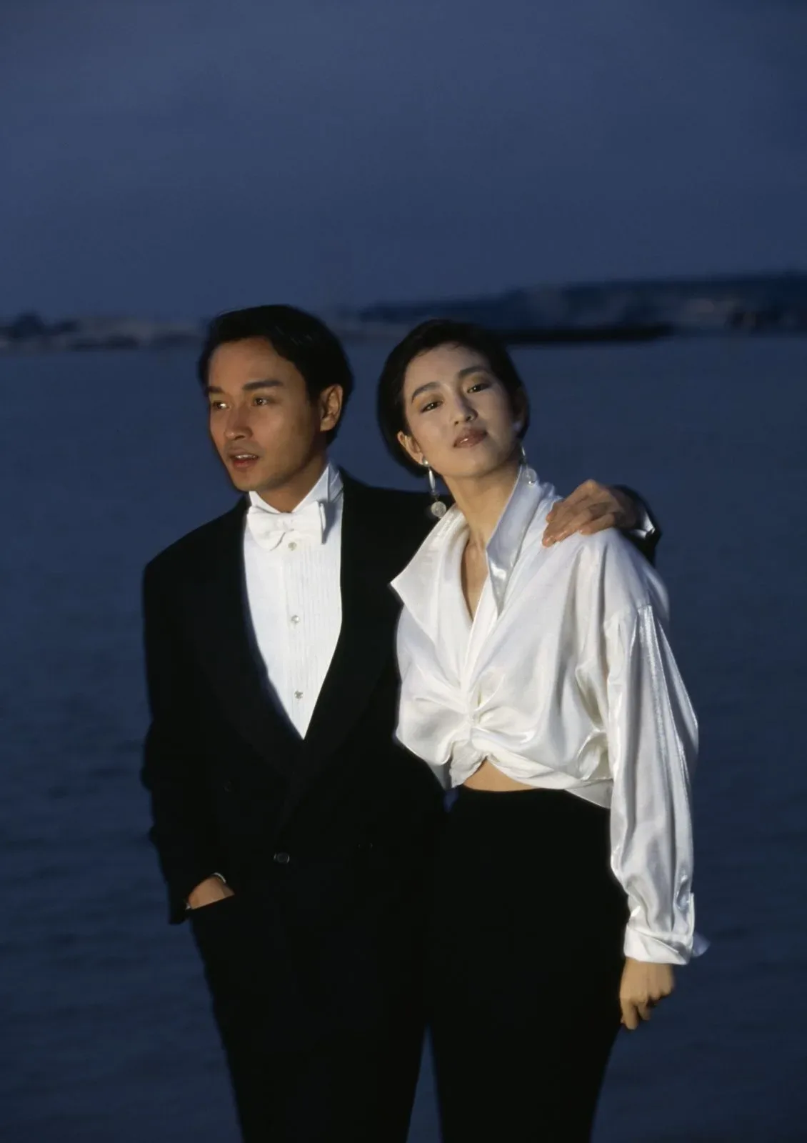 Gong Li in a white shirt with Leslie Cheung on the beach at Cannes, 1993