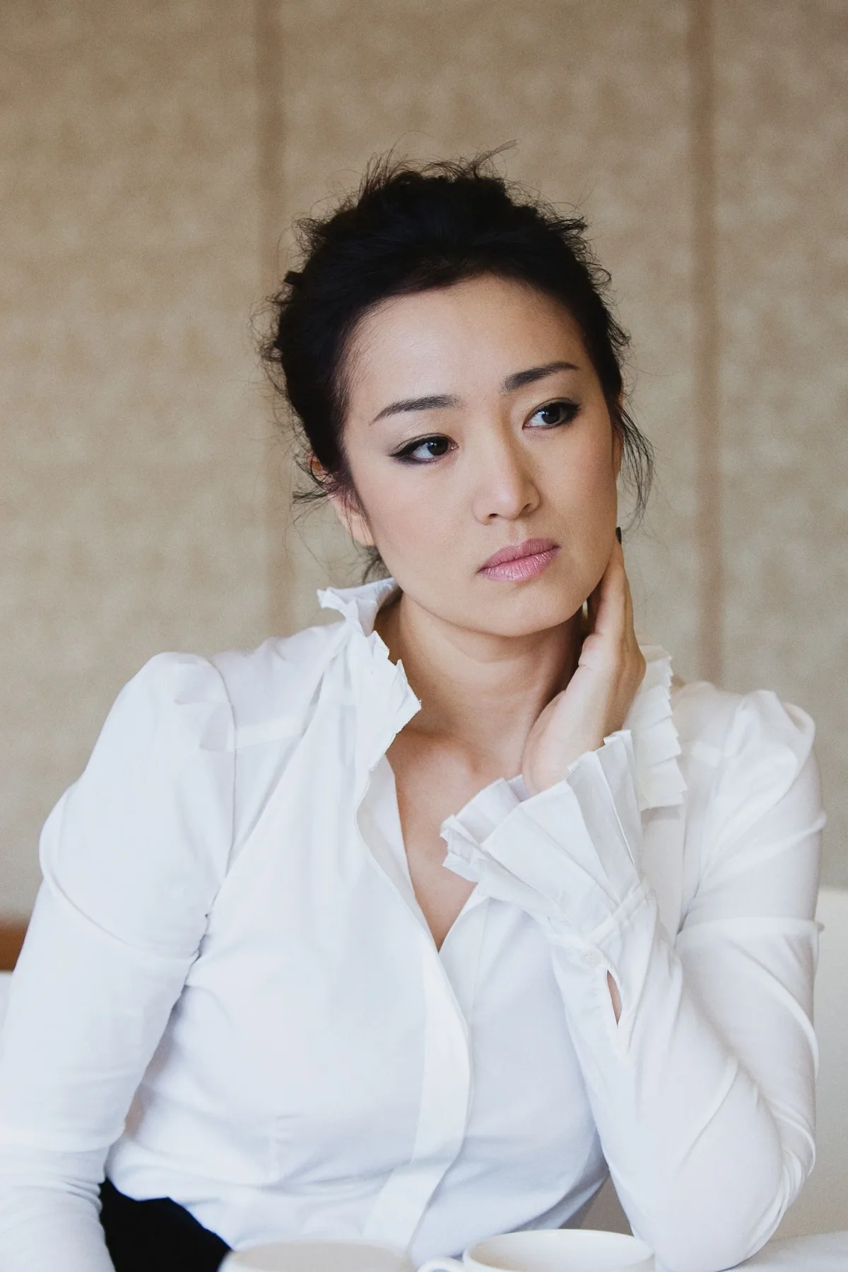 Gong Li in a white shirt, seated portrait