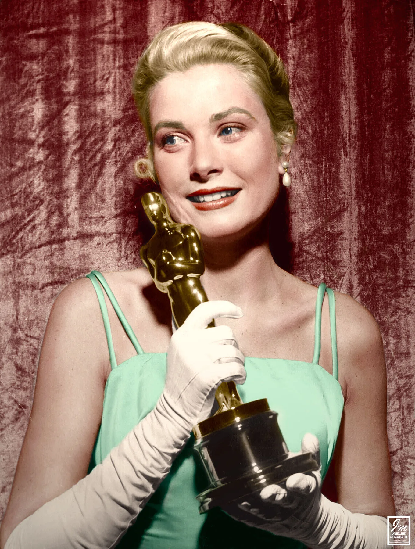Grace Kelly in her ice-blue satin gown holding her Oscar in front of a red curtain, 1955
