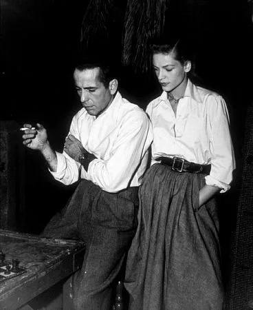 Humphrey Bogart and Lauren Bacall riding bicycles at the Warner Bros. studios during Key Largo, 1948
