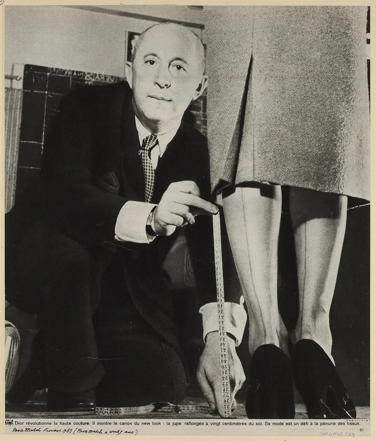 Christian Dior (21 January 1905 – 24 October 1957)  at work, measuring hemline