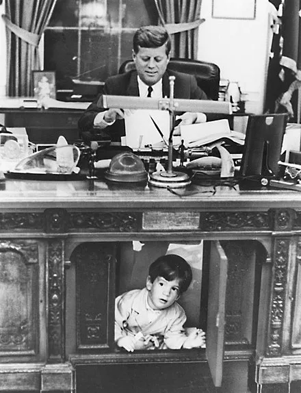 John F. Kennedy Jr. as a small boy playing under his father's desk in the Oval Office, White House, 1963